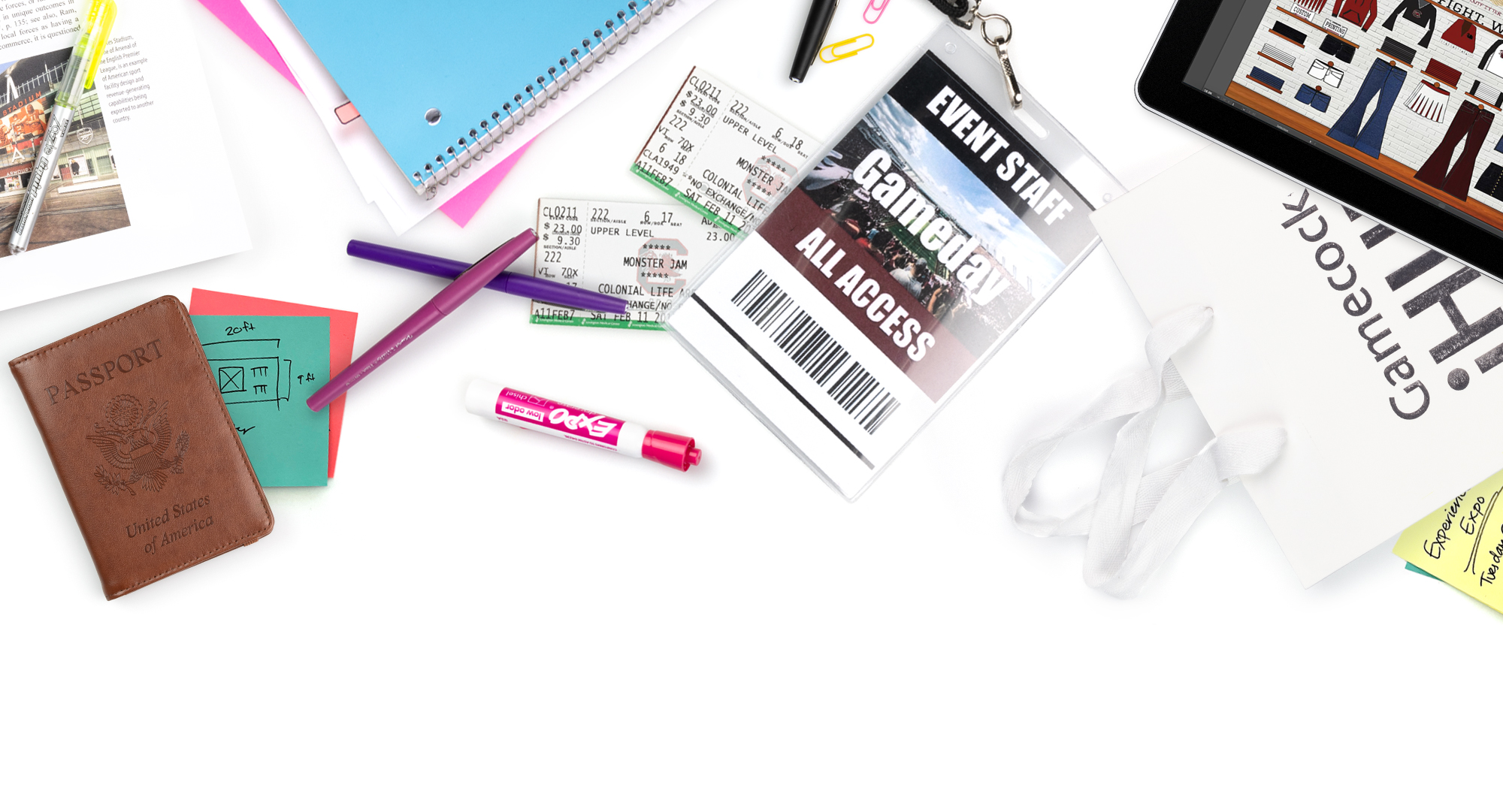 Various items representing the College of Hospitality, Retail and Sport Management including an event pass and tickets, a napkin and silverware, notebooks, pens and an iPad and an iHub bag.