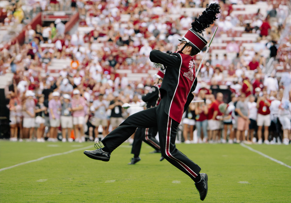 Drum major high-stepping across the football field
