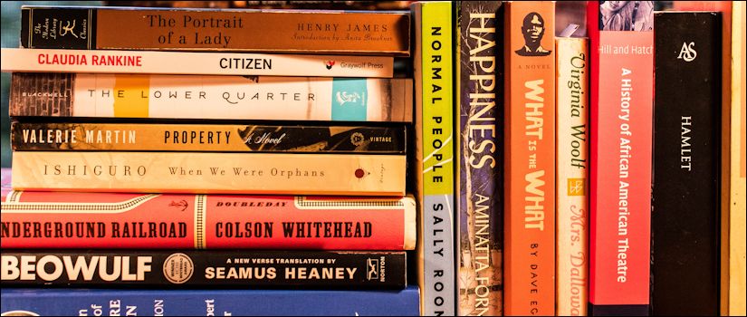 Stacked English course books lying horizontally on a desktop