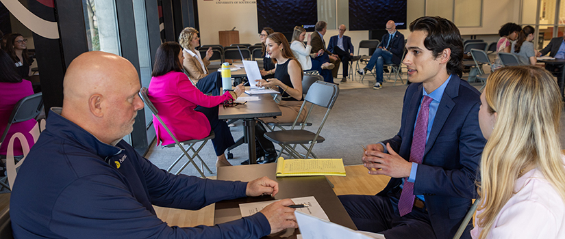 Students interviewing with an employer at HRSM networking event