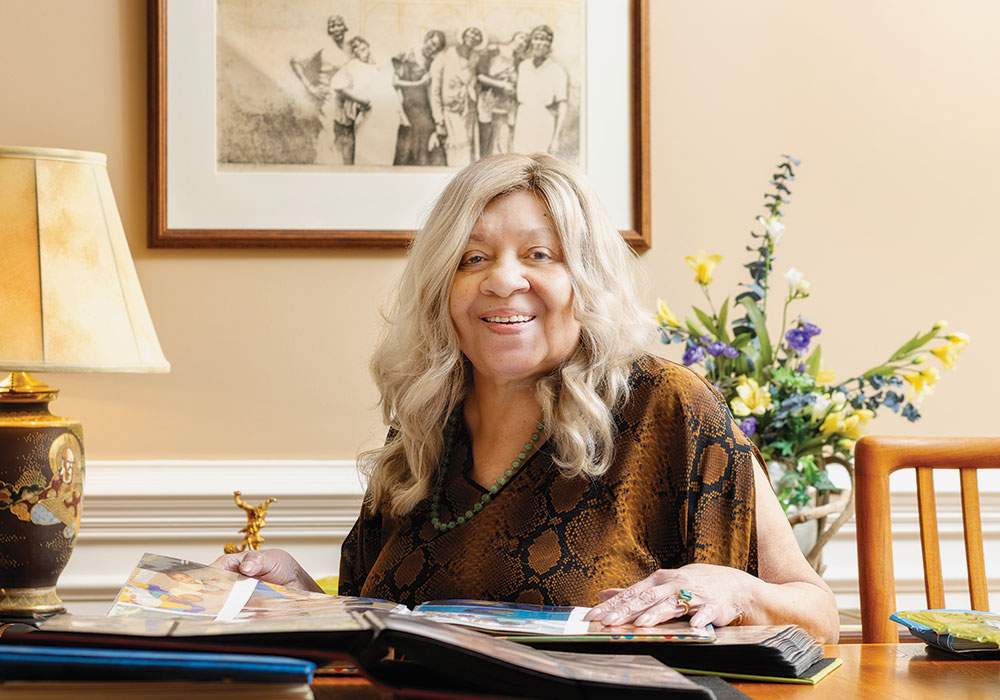 Henrie Monteith Treadwell smiles while looking at scrapbooks from her past.