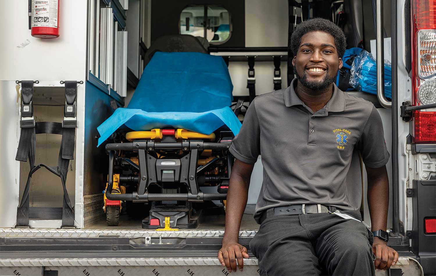 Tremayne Ansani sits on the tailgate of an ambulance.